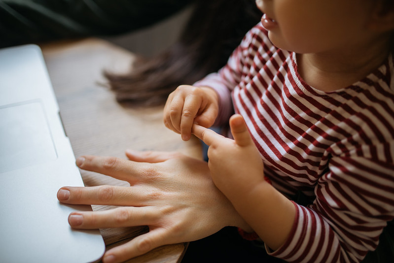 Little girl with her mom looking at laptop